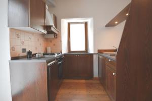 una cocina con armarios de madera y una ventana en Baceno Home, en Baceno