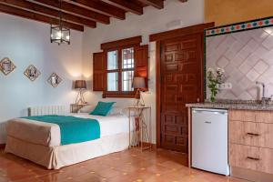 a bedroom with a bed and a sink in a room at SUITES CASA DE LAS COLUMNAS in Granada