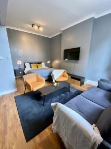 a living room with a blue couch and a bed at Stylish Studio near Regents Park n6 in London