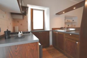 una cucina con armadi in legno e una finestra di Baceno Home a Baceno