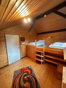 a room with two bunk beds and a rug at Gemütliches Ferienhaus im Grünen in Bernau im Schwarzwald