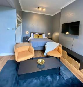 a bedroom with a bed and two chairs and a tv at Stylish Studio near Regents Park n6 in London