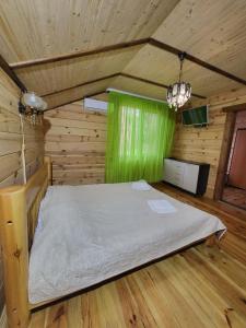 1 dormitorio con 1 cama en una habitación de madera en База відпочинку Діана, en Szack