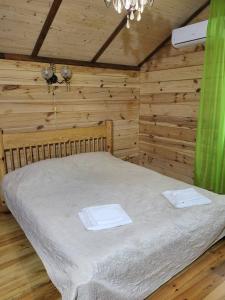 Szack的住宿－База відпочинку Діана，木制客房内的一间卧室,配有一张床