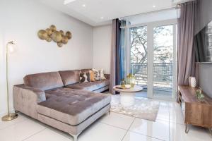 a living room with a couch and a table at Urban Oasis Apartments at The Median in Johannesburg