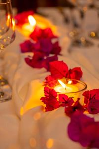 a candle on a table with red flowers on it at Country Club Eco Casajardin in Moyobamba