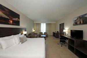 a hotel room with a bed and a flat screen tv at Victoria Hotel and Suites Panama in Panama City