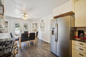 a kitchen with a refrigerator and a table with chairs at Charming Pet Friendly Coastal Getaway home in Fort Bragg