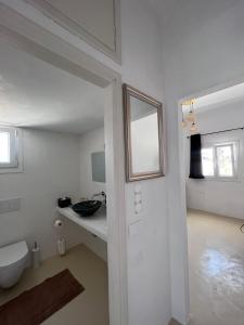 a white bathroom with a toilet and a sink at suite diminutif 2 in Adamas