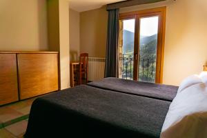 a bedroom with a bed and a large window at Hotel Ransol in El Tarter