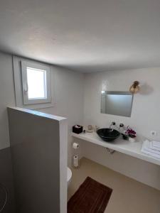 a bathroom with a sink and a mirror at suite diminutif 2 in Adamas