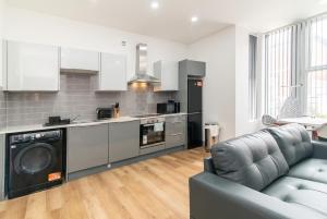 a living room with a couch and a kitchen at 1BR Derby City Centre Flat 1 - Charnwood Flats in Derby