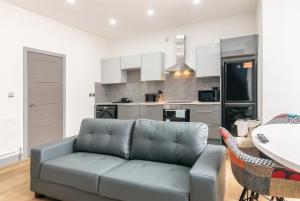 ein Wohnzimmer mit einem Sofa und einer Küche in der Unterkunft 1BR Derby City Centre Flat 1 - Charnwood Flats in Derby