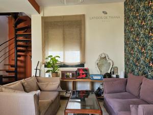 a living room with a couch and a table at Latidos de Triana - ático con vistas a todo Sevilla in Seville