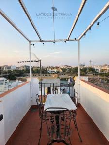 a table and chairs on a balcony with a view at Latidos de Triana - ático con vistas a todo Sevilla in Seville