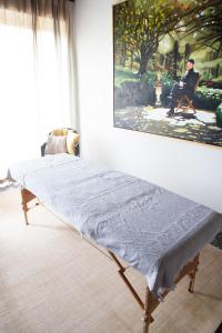 a bed in a room with a painting on the wall at Maisonnette FREA in Rozebeke