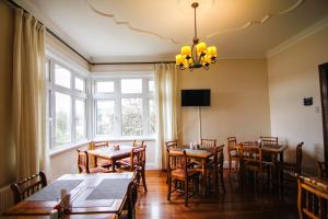 uma sala de jantar com mesas e cadeiras e um lustre em Hotel Costanera - Caja Los Andes em Valdivia