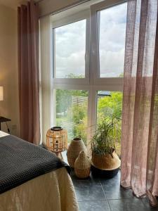 ein Schlafzimmer mit einem Fenster mit Topfpflanzen davor in der Unterkunft Villalägenhet i Askim med havsutsikt in Göteborg