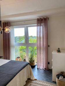 a bedroom with a large window and a bed at Villalägenhet i Askim med havsutsikt in Gothenburg