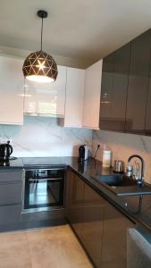 a kitchen with white cabinets and a sink and a light at Apartament Azul in Cieszyn