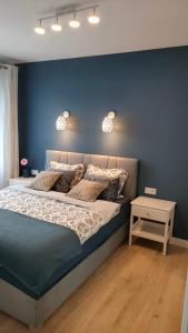 sypialnia z łóżkiem i niebieską ścianą w obiekcie Apartament Azul w mieście Cieszyn