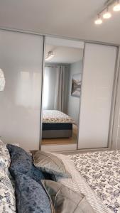 a bedroom with two mirrors in front of a bed at Apartament Azul in Cieszyn