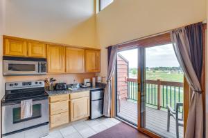a kitchen with a stove top oven next to a balcony at Wisconsin Dells Condo with Pool and Resort Amenities! in Wisconsin Dells