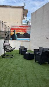 a bench on the grass with a painting on a wall at Comfort La tombola tripla deluxe in Naples