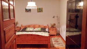 a bedroom with a wooden bed and a chandelier at Agroturystyka Mazury Cicha Wólka in Zawady