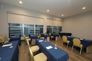 パナマシティにあるVictoria Hotel and Suites Panamaのカンファレンスルーム(青いテーブル、椅子、窓付)