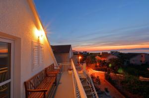 a balcony with benches on a building with a sunset at ꕥ ROOMS SUNCE, Family choice, Best Panoramic view, Supetar Island Brac in Supetar