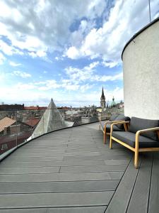 a balcony with two chairs and a view of a city at VP Suites in Budapest