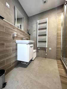 bagno con lavandino bianco e specchio di VP Suites a Budapest