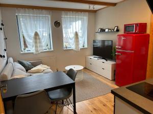 a kitchen with a red refrigerator and a living room at Privat Apartment mit Kreischberg-Blick in Lutzmannsdorf