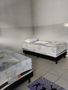 two beds in a room with two mattresses at Pousada da Dora in Prado