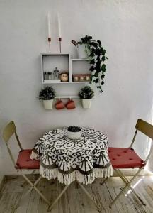 a table with two chairs and a table with plants at La Marieta, casita acogedora y centrica in Castilleja de la Cuesta