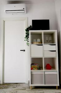 a white book shelf with a tv and a door at La Marieta, casita acogedora y centrica in Castilleja de la Cuesta