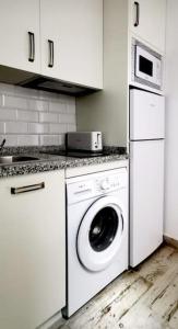 a kitchen with a washing machine and a washer at La Marieta, casita acogedora y centrica in Castilleja de la Cuesta