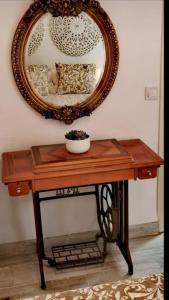 una mesa de madera con un espejo en la pared en La Marieta, casita acogedora y centrica, en Castilleja de la Cuesta