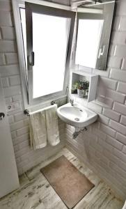 baño blanco con lavabo y ventana en La Marieta, casita acogedora y centrica, en Castilleja de la Cuesta