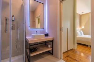 a bathroom with a sink and a shower with a mirror at Liberdade Concept 1BDR Apartment by LovelyStay in Lisbon