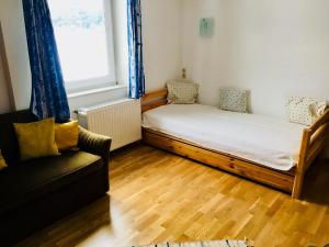 Zimmer mit einem Bett, einem Sofa und einem Fenster in der Unterkunft Haus Martina in Ehrwald