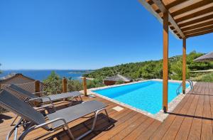 een houten terras met een zwembad en een tafel en stoelen bij Golden Haven Luxe Glamp Resort in Murter