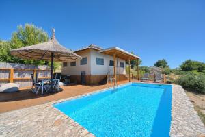 a villa with a swimming pool and a house at Golden Haven Luxe Glamp Resort in Murter