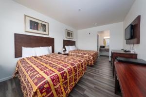 pokój hotelowy z 2 łóżkami i telewizorem z płaskim ekranem w obiekcie America Inn & Suites w mieście Ridgecrest