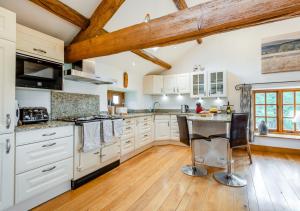 a kitchen with white cabinets and a wooden floor at Knipe Fold Barn in Hawkshead