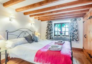 1 dormitorio con 1 cama grande con manta roja en Knipe Fold Barn en Hawkshead