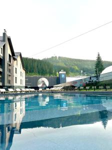 a large pool of water with a train in the background at Premium hotel & SPA in Bukovel