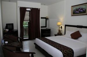 a bedroom with a bed and a chair and a window at Luta Resort Toraja in Rantepao