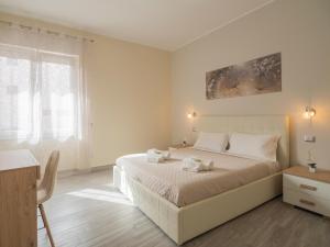1 dormitorio blanco con 1 cama grande con almohadas blancas en Sweet Dreams - MORADA, en Cagliari